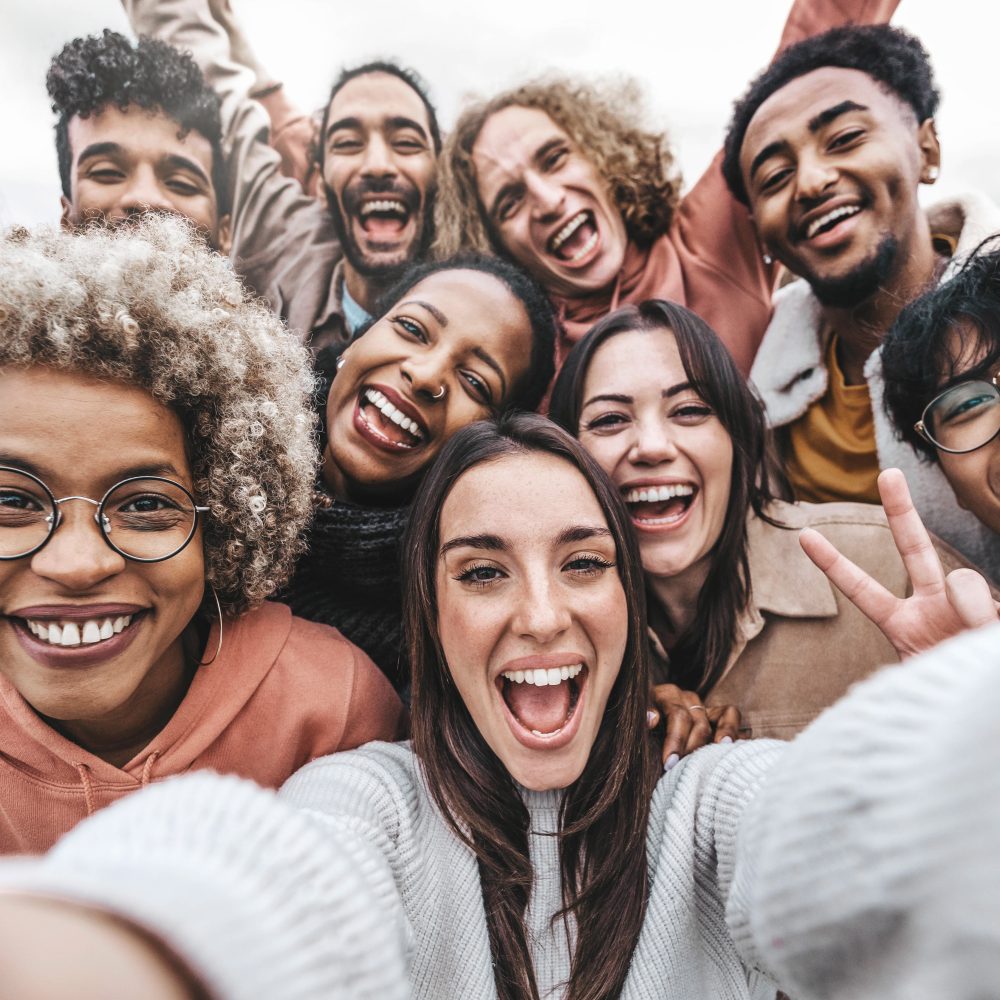 Multicultural community of young people smiling together at camera